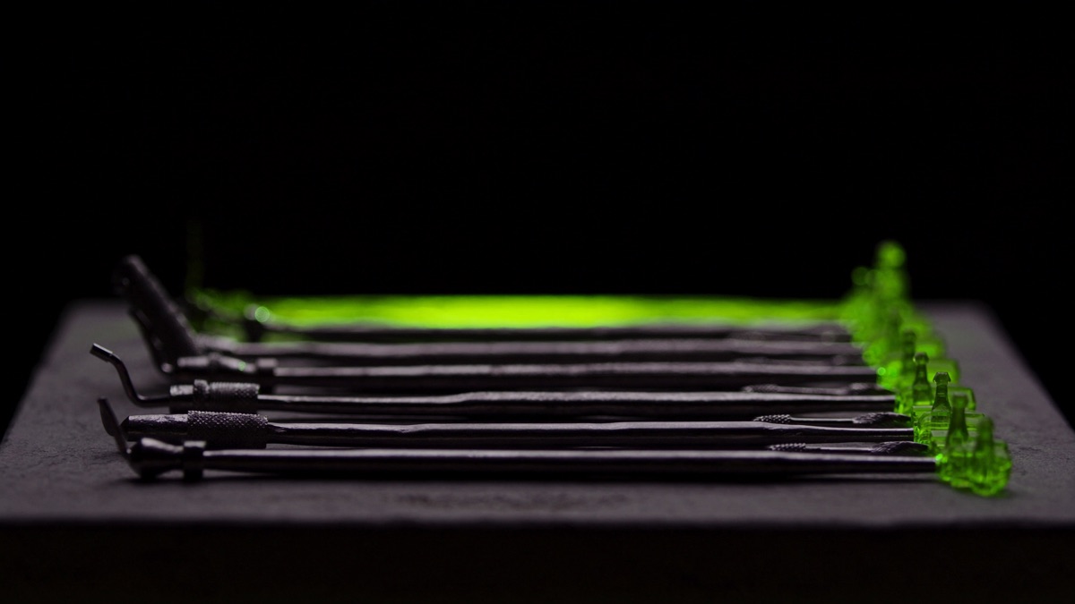Zahnärztliche Präzisionsinstrumente liegen streng geometrisch gereiht auf dunklem Stein, dahinter zeichnet eine chartreuse-grüne Lichtkante die gestaffelten Kosten einer Zahnarzt-Website in der Schweiz nach.